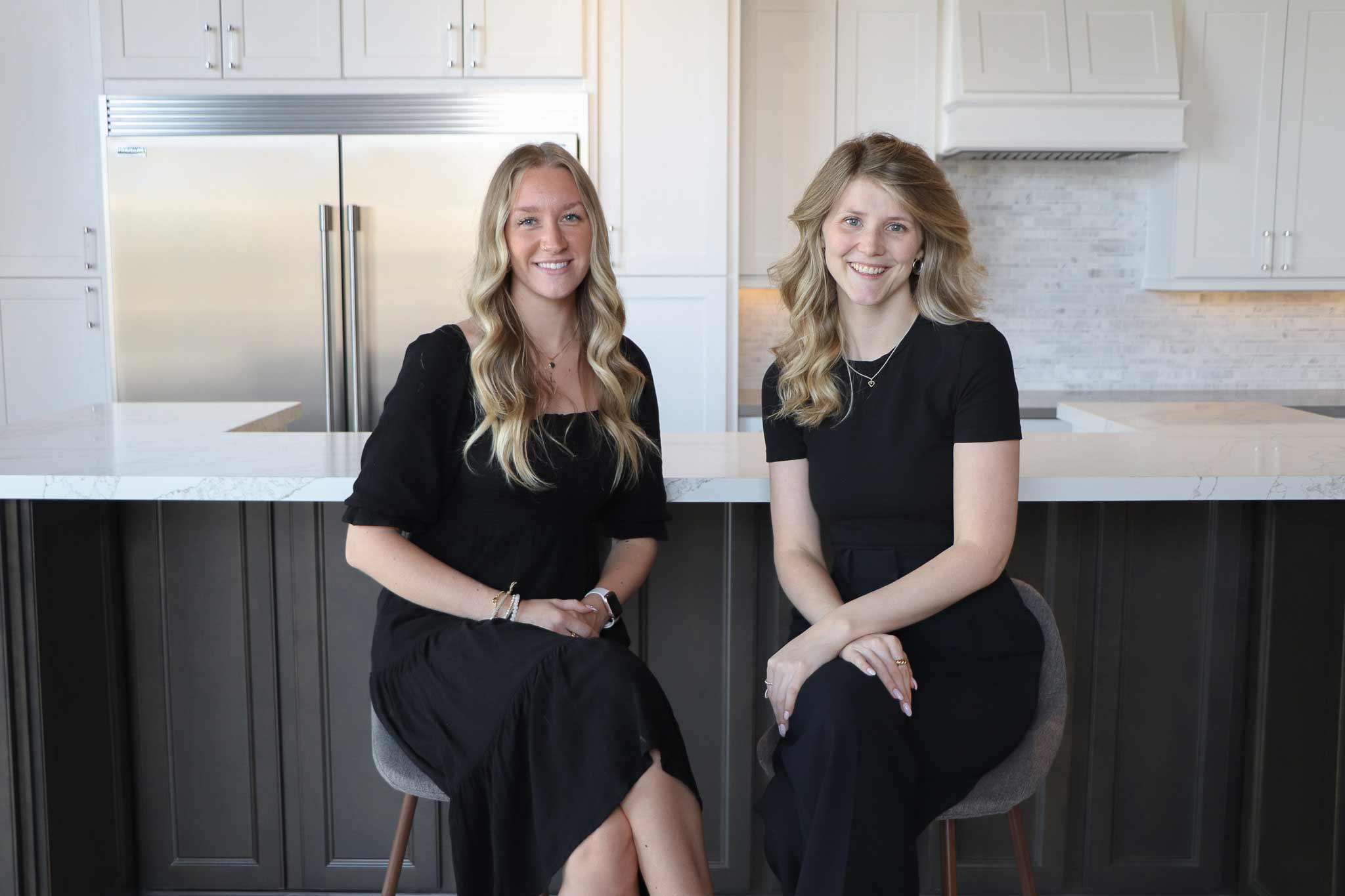 Two RockWood Kitchens designers sit at a kitchen display in one of our showrooms.